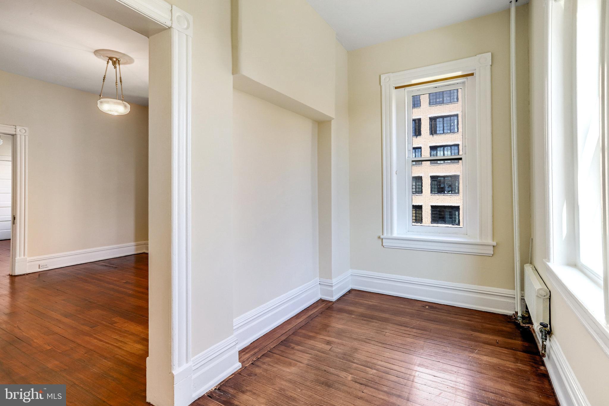 1633 16th Street Northwest Washington, DC 20009 - Photo 82 of 130 a view of an empty room with wooden floor and a window