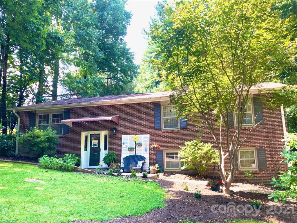 a front view of a house with a yard and trees