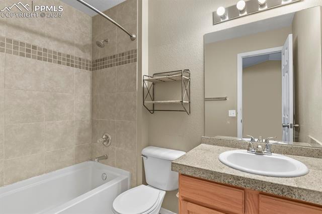 11032 Berry Farm Road Fountain, CO 80817 - Photo 23 of 35 Bathroom featuring a textured wall, shower / washtub combination, and vanity