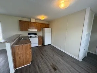 a kitchen with wooden floors and wooden cabinets