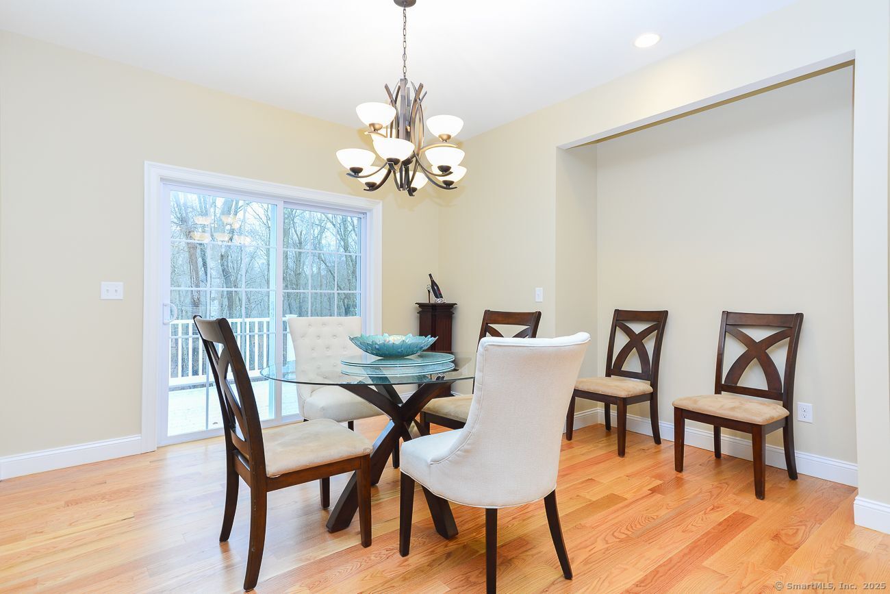 10 Fort Hill Road, Unit 3B Groton, CT 06340 - Photo 6 of 24 a view of a dining room with furniture a chandelier and wooden floor