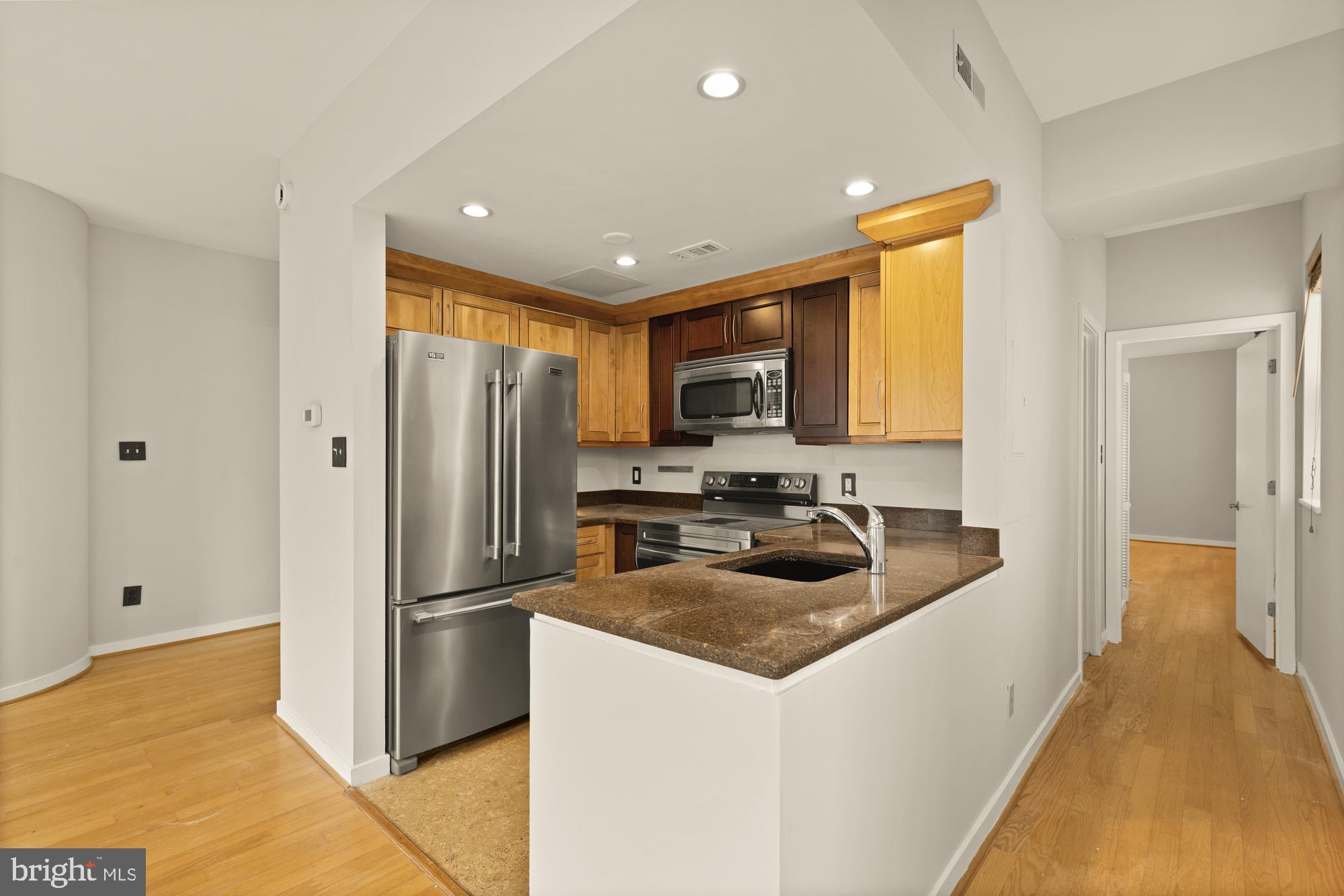 2114 N Street Northwest, Unit 11 Washington, DC 20037 - Photo 13 of 23 a kitchen with refrigerator a microwave a sink and cabinets