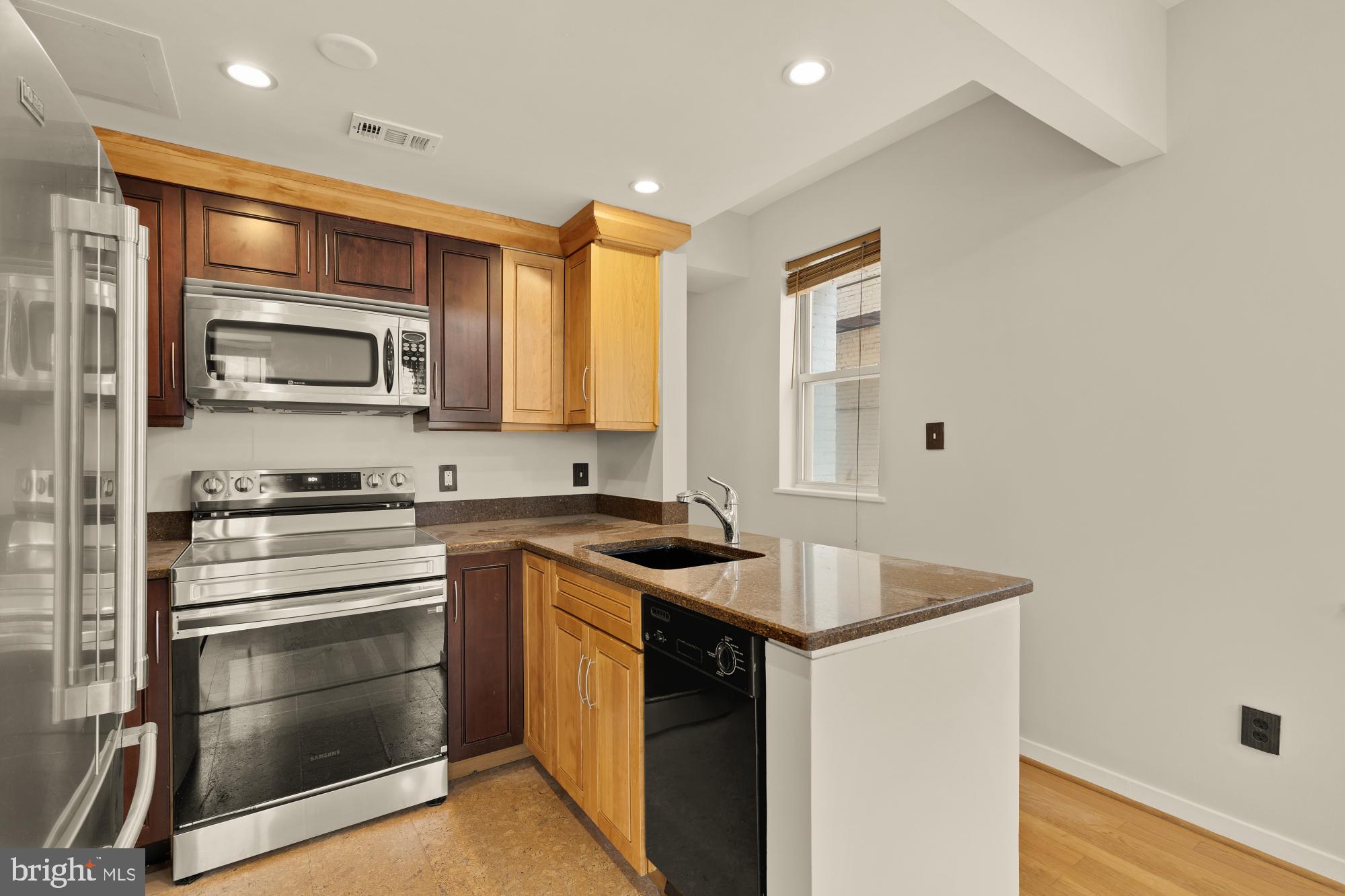 2114 N Street Northwest, Unit 11 Washington, DC 20037 - Photo 14 of 23 a kitchen with stainless steel appliances granite countertop a sink stove and microwave