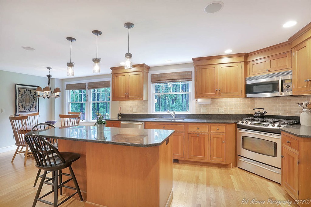 17 Janes Road Boxford, MA 01921 - Photo 3 of 29 a kitchen with stainless steel appliances granite countertop a stove a sink dishwasher and a wooden table with cabinets