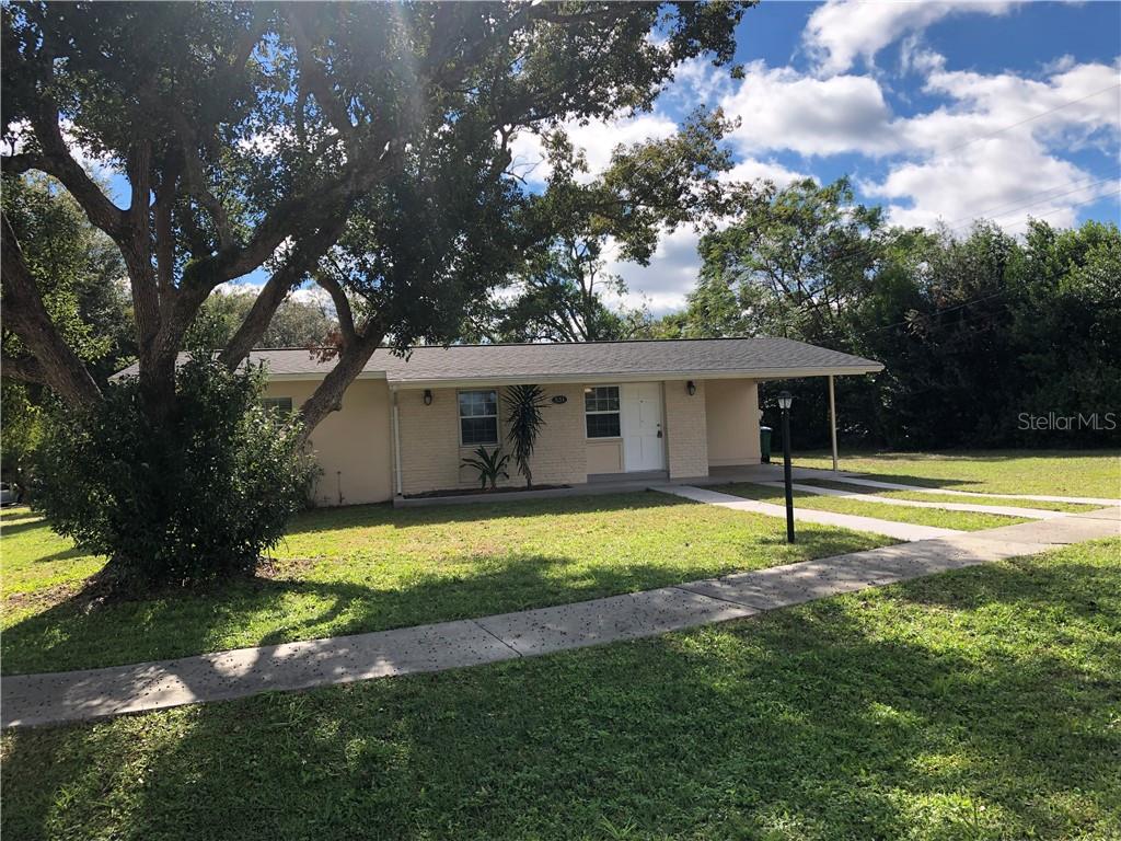 a view of a house with a yard tree and a big yard