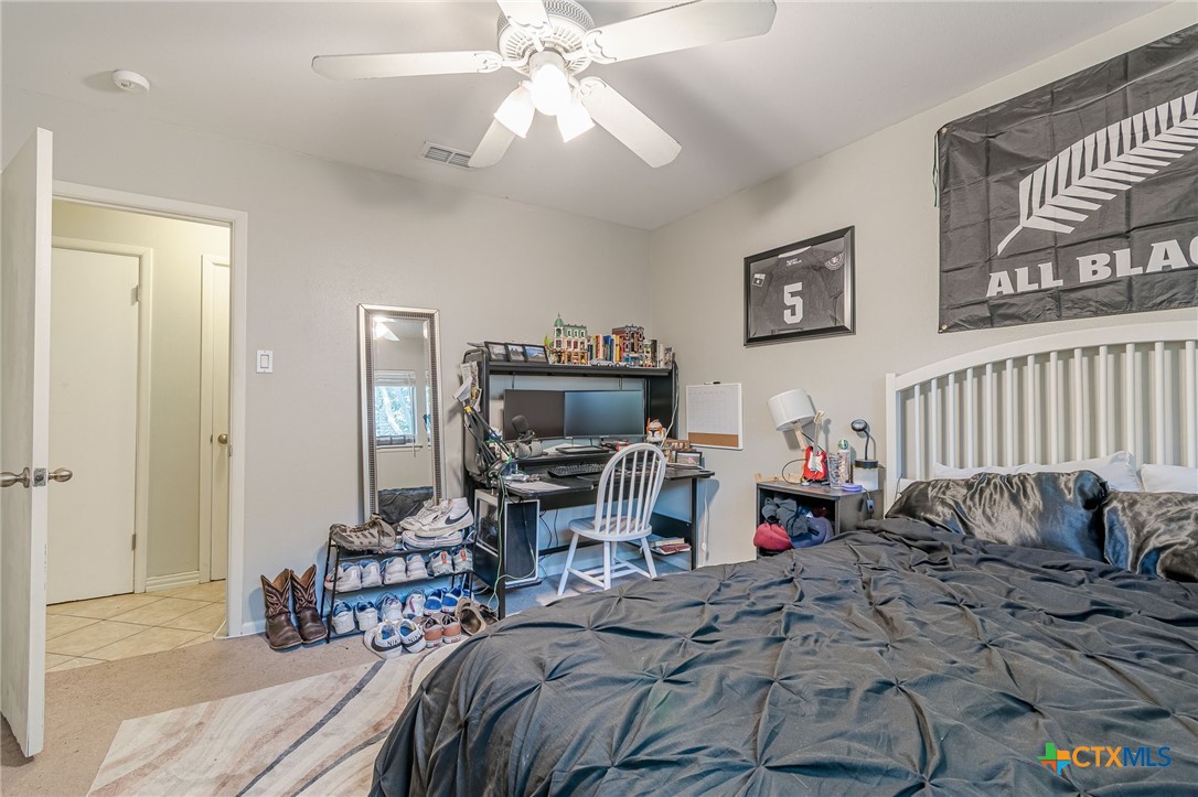 133 Algarita Road San Marcos, TX 78666 - Photo 11 of 43 a bedroom with bed and a chandelier