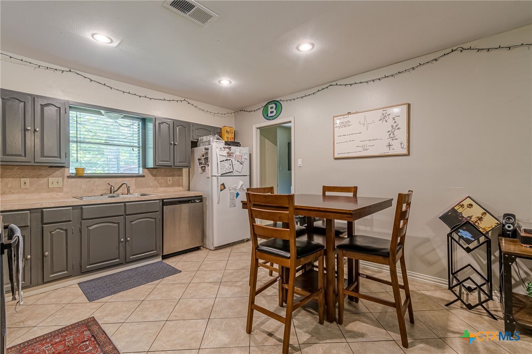133 Algarita Road San Marcos, TX 78666 - Photo 20 of 43 a kitchen with stainless steel appliances granite countertop a table and chairs in it