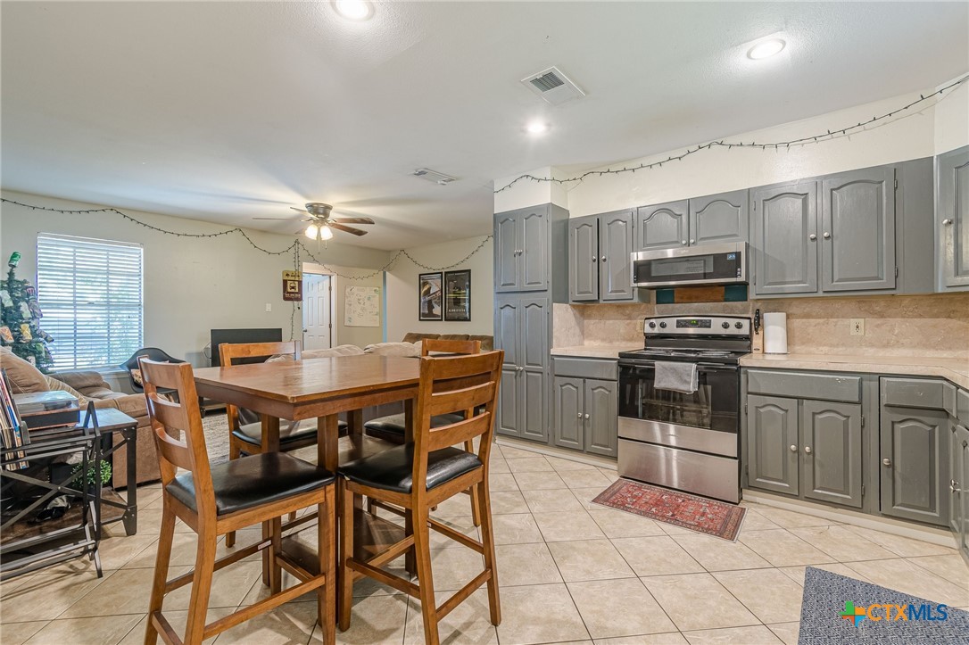 133 Algarita Road San Marcos, TX 78666 - Photo 24 of 43 a kitchen with stainless steel appliances kitchen island granite countertop a dining table chairs and granite counter tops