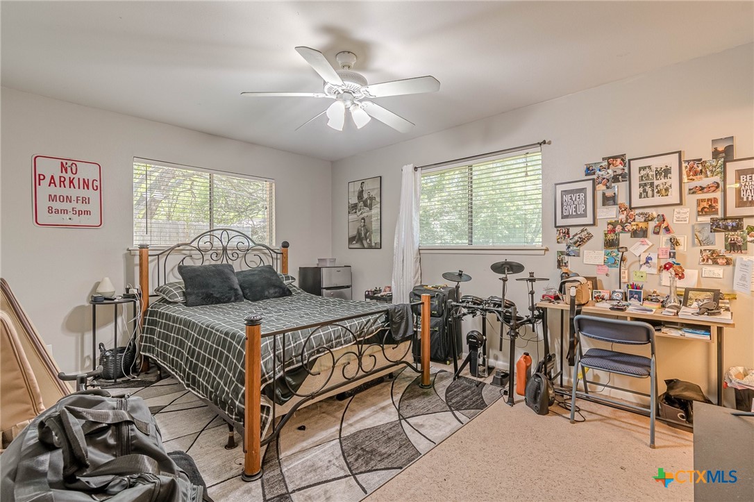 133 Algarita Road San Marcos, TX 78666 - Photo 29 of 43 a bedroom with a bed gym equipment and a large window