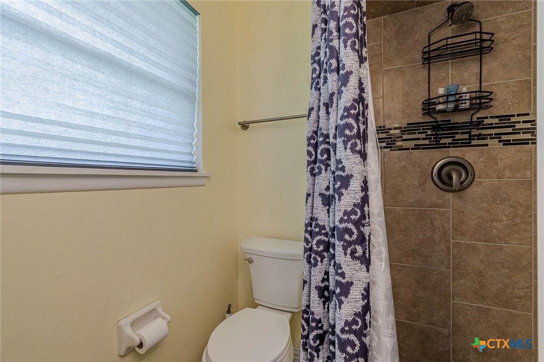 133 Algarita Road San Marcos, TX 78666 - Photo 33 of 43 a bathroom with a toilet and a shower curtain