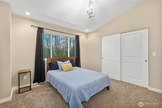 a bedroom with a large bed and a chandelier