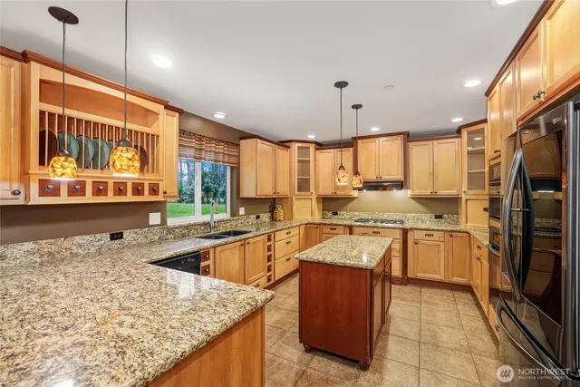 a kitchen with stainless steel appliances granite countertop a sink stove and refrigerator