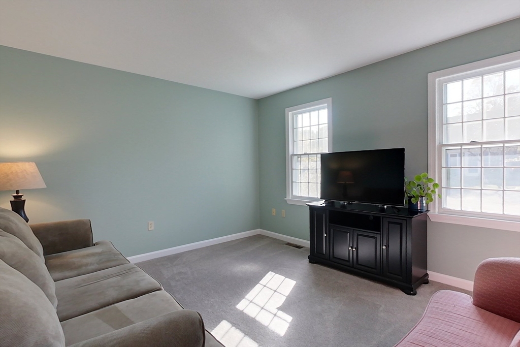 8 Tucker Park, Unit D Pepperell, MA 01463 - Photo 11 of 35 a living room with furniture and a flat screen tv