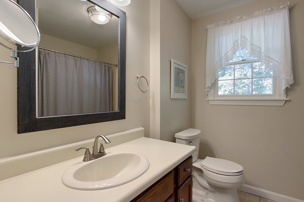 8 Tucker Park, Unit D Pepperell, MA 01463 - Photo 25 of 35 a bathroom with a toilet a sink and mirror