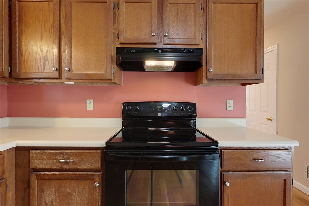 8 Tucker Park, Unit D Pepperell, MA 01463 - Photo 5 of 35 a kitchen with stainless steel appliances granite countertop a stove and a microwave