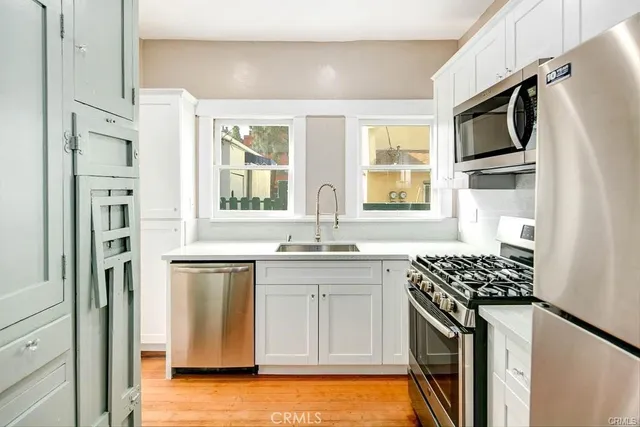 a kitchen with stainless steel appliances a sink stove and refrigerator