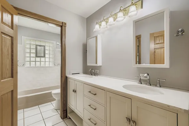 a bathroom with a sink double vanity granite tub and a mirror