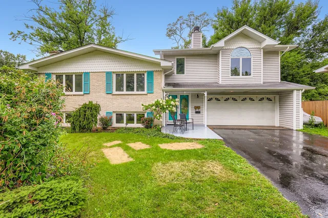 a front view of a house with yard and green space