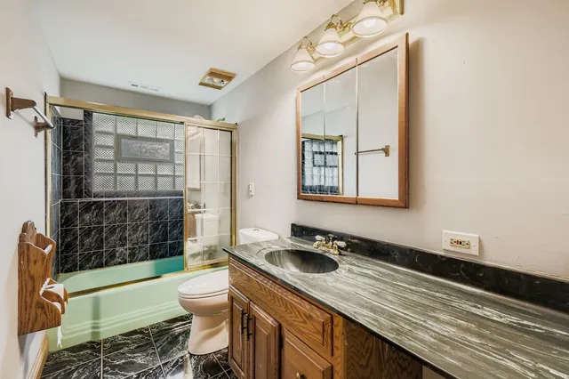 a bathroom with a sink a toilet a mirror and shower