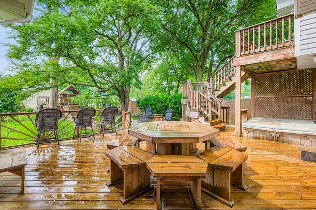 a view of a patio with table and chairs with wooden floor and fence