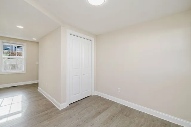 an empty room with wooden floor and white walls