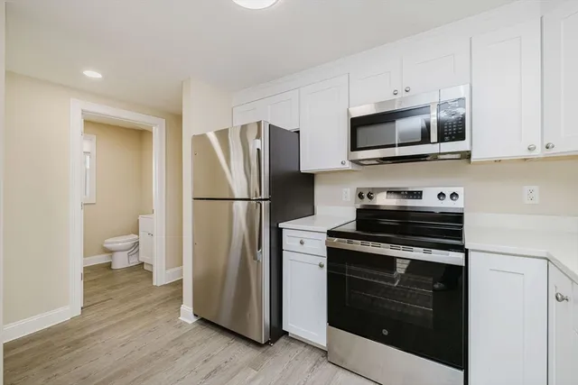 a kitchen with a refrigerator stove and white cabinets
