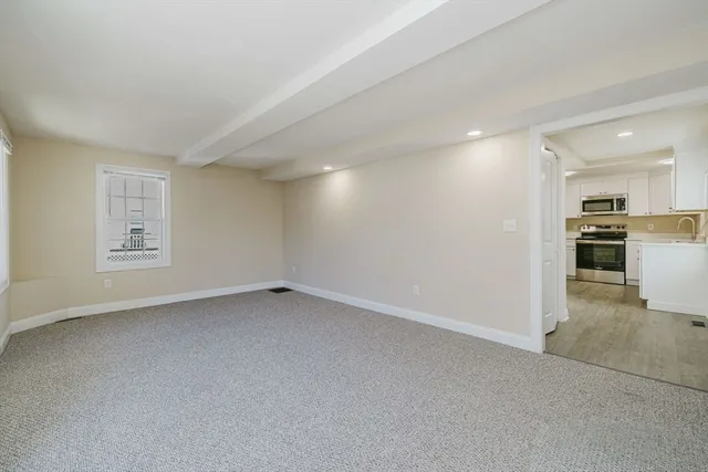 an empty room with windows and electric appliances