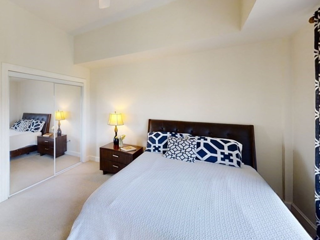 36 Village Road, Unit 713 Middleton, MA 01949 - Photo 19 of 39 a bedroom with a bed and a lamp