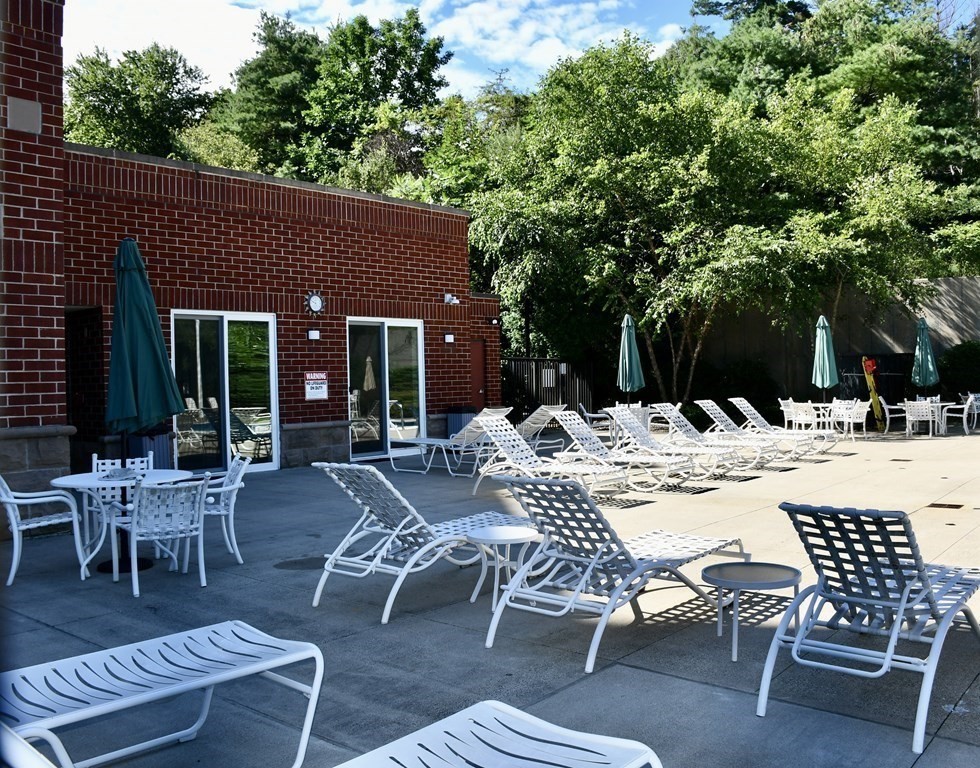 36 Village Road, Unit 713 Middleton, MA 01949 - Photo 35 of 39 a view of a patio with a dining table and chairs with wooden fence