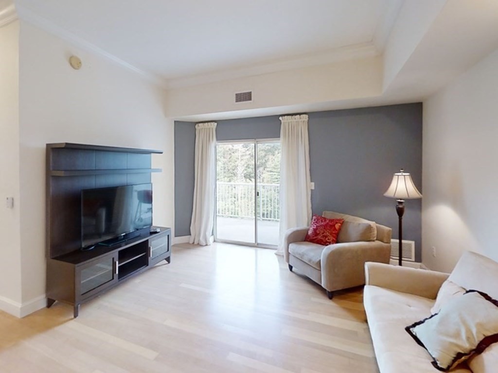 36 Village Road, Unit 713 Middleton, MA 01949 - Photo 4 of 39 a living room with furniture a flat screen tv and a fireplace