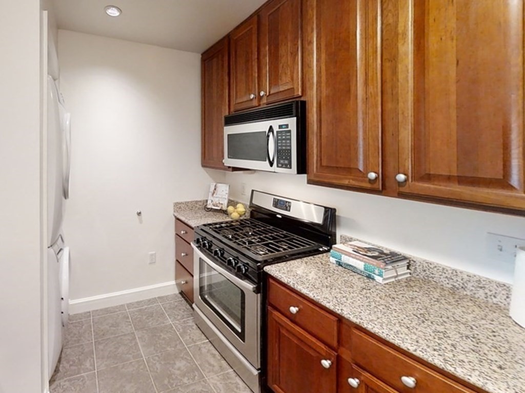 36 Village Road, Unit 713 Middleton, MA 01949 - Photo 9 of 39 a kitchen with granite countertop cabinets stainless steel appliances and a sink