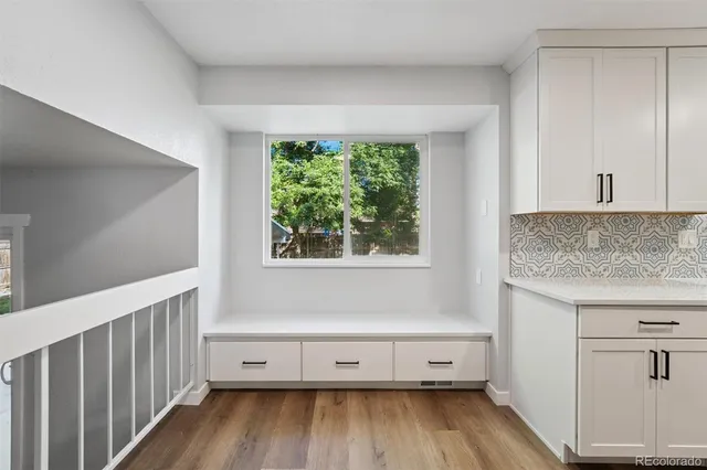 a view of workspace with wooden floor and a window