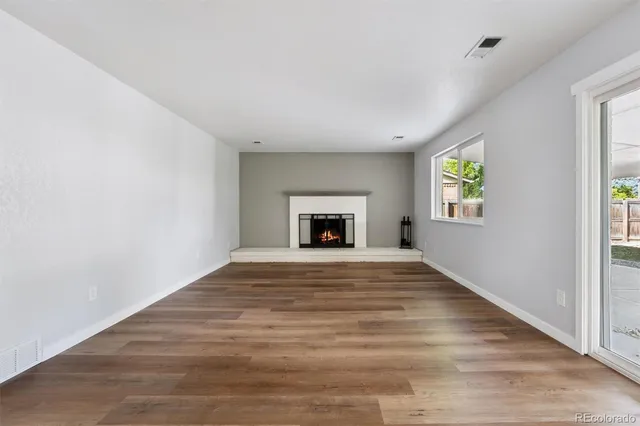 a big room with wooden floor and a window