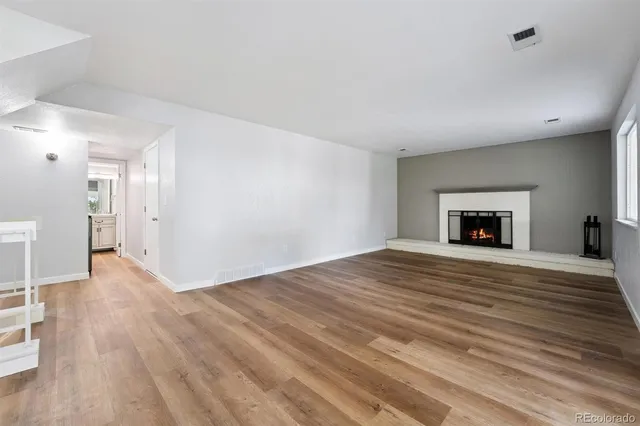a big room with wooden floor and a window