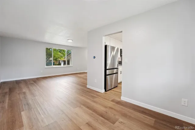 a view of empty room with wooden floor and window