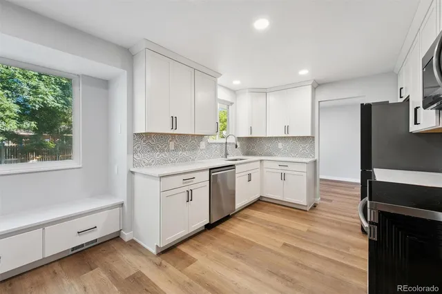 a kitchen with granite countertop white cabinets and white appliances