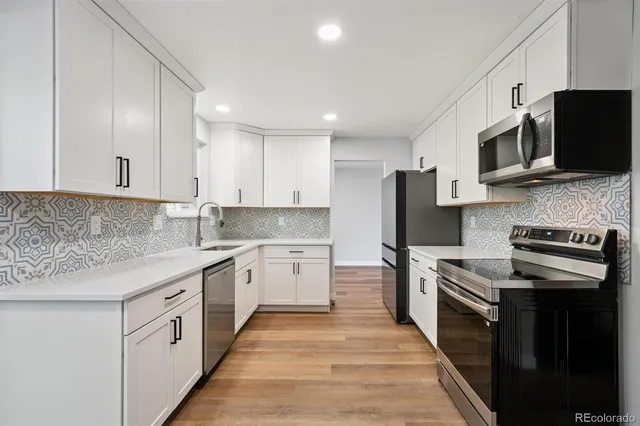 a kitchen with stainless steel appliances granite countertop a stove top oven a sink dishwasher and a refrigerator with wooden cabinets