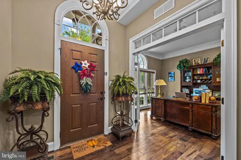 a living room with furniture a potted plant and kitchen view