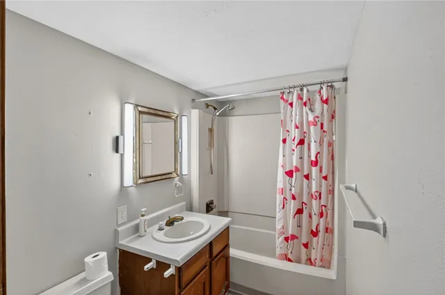 a bathroom with a sink a toilet and shower curtain