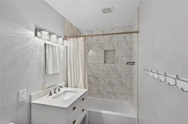 a bathroom with a shower a sink and a mirror