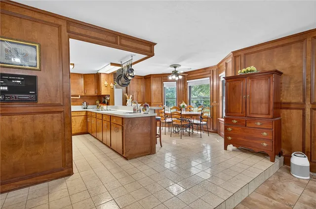 a kitchen with stainless steel appliances kitchen island granite countertop a refrigerator and cabinets