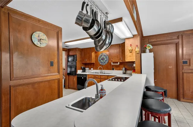 a kitchen with stainless steel appliances granite countertop a sink a refrigerator a stove and a refrigerator