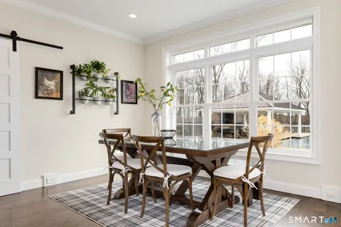 a view of a dining room with furniture large window and wooden floor