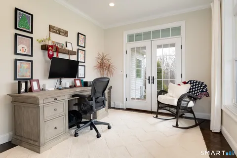 a view of a workspace with furniture and a window
