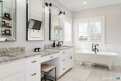 a spacious bathroom with a double vanity sink a mirror and a bathtub