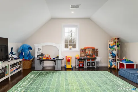 a living room with furniture a baby crib and a wooden floor