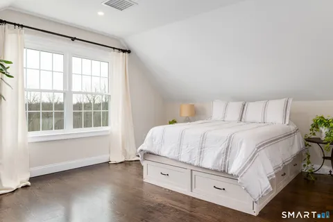 a spacious bedroom with a bed and a window