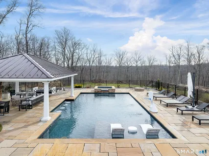 a view of a patio with couches table and chairs with wooden fence