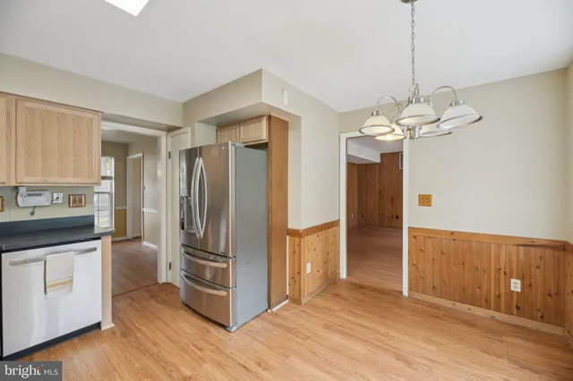 a kitchen with stainless steel appliances granite countertop a refrigerator a sink and a stove