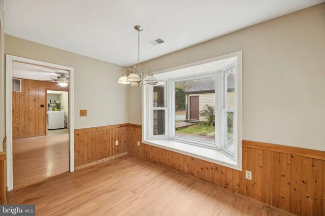 a view of a hallway with wooden floor and a living room